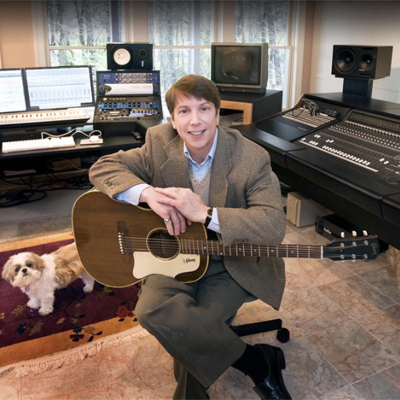 Dennis Scott with guitar in his studio